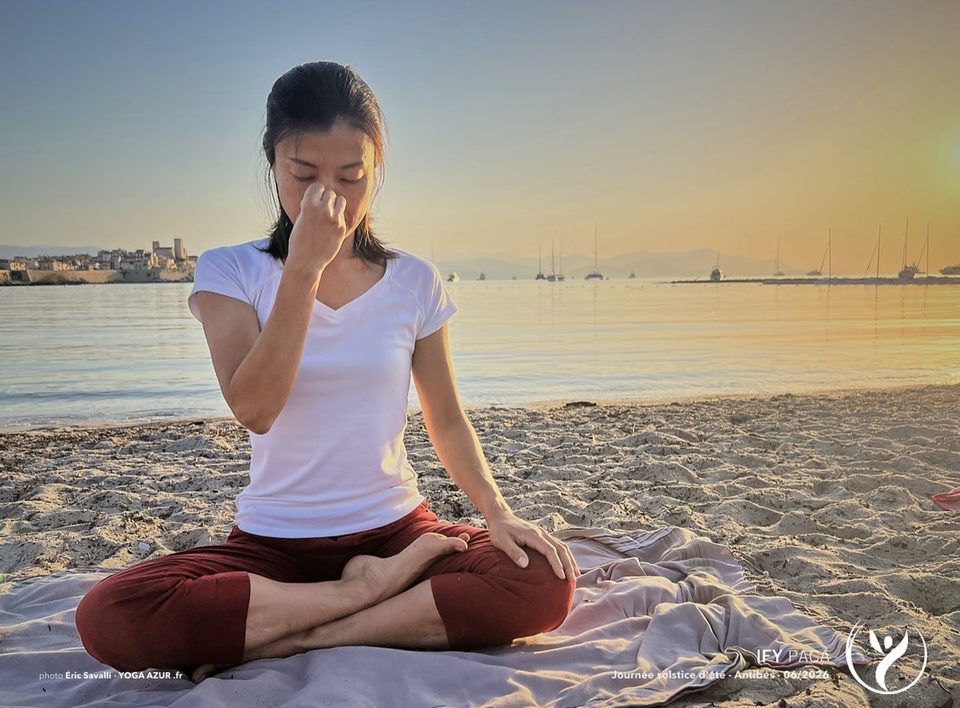 Pratique de respiration assise sur une plage, la mer en arrière-plan.